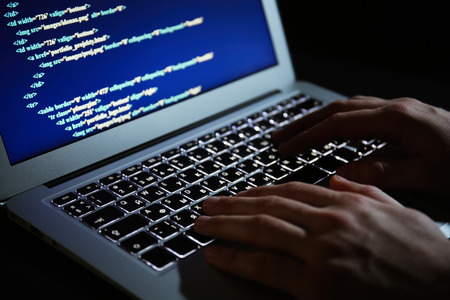 Hacker using laptop, closeup