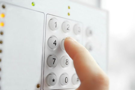 Security alarm keypad with male hand, closeupの写真素材
