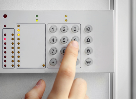 Security alarm keypad with male hand, closeupの写真素材