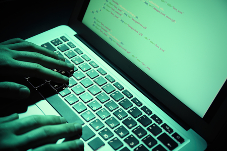 Hacker using laptop, closeupの写真素材