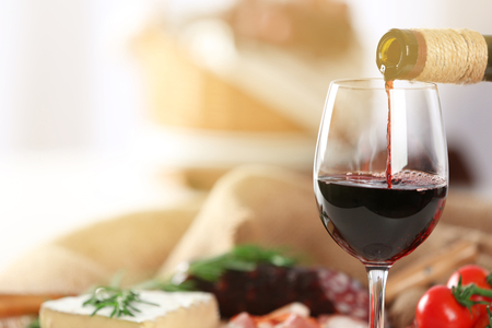 Glass of wine with food on table closeupの写真素材