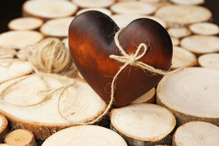 Brown heart with rope on wood log backgroundの写真素材