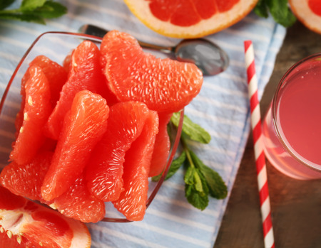 Ripe grapefruits and fresh juice with mint, close upの写真素材