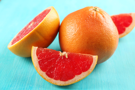 Juicy grapefruits on blue background, close upの写真素材