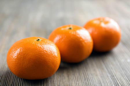 Fresh delicious tangerines lined on the wooden table, close upの写真素材