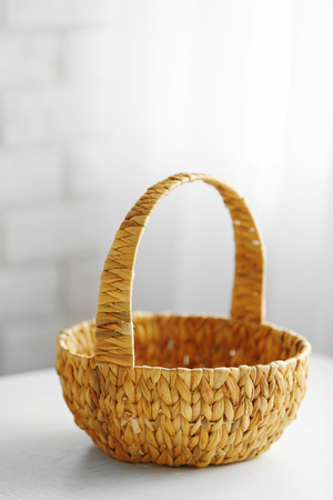 Wicker basket with handle on wooden table, closeupの写真素材