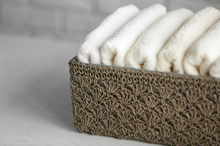 Wicker basket with towels inside on wooden table backgroundの写真素材