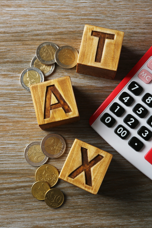 Tax concept with wooden blocks, coins and calculator, closeupの写真素材