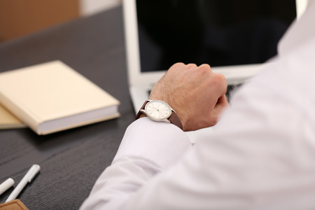 Businessman checking the time on his wrist watch, close upの写真素材