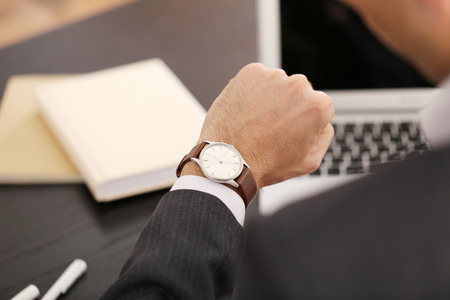 Businessman checking the time on his wrist watch, close upの写真素材