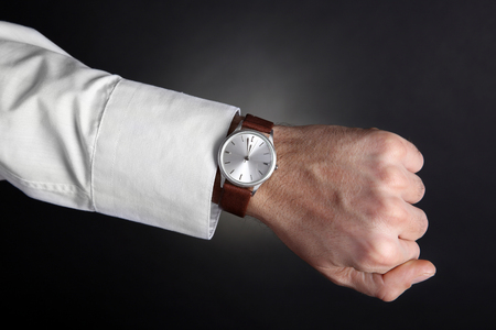 Modern watch on a businessman's wrist over black backgroundの写真素材