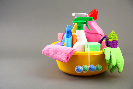 Detergent bottles and cleaning supplies in a bowlの写真素材