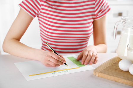 Young woman writing a diet planの写真素材