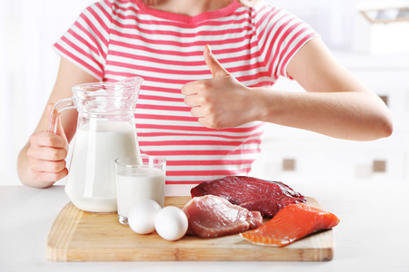Woman with diet food showing thumbの写真素材