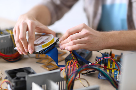 Young man repairing computer hardware in service center