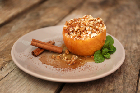 Baked apple with honey, raisins and walnut on plateの写真素材