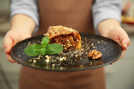 Woman holding plate with an apple rollの写真素材