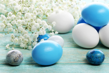 Blue and white Easter eggs with flowers on wooden table closeupの写真素材