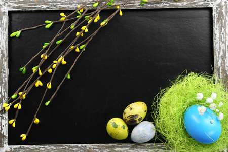 Eaters eggs with blooming willow branches on blackboard, top viewの写真素材