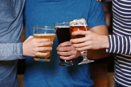 Group of young people holding their glasses of beerの写真素材