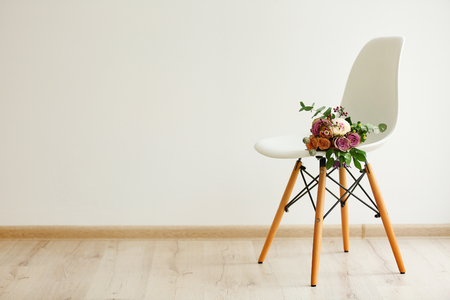 Bouquet of roses on a white chair in roomの写真素材
