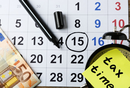 Tax time on alarm clock with euro, marker and calendarの写真素材
