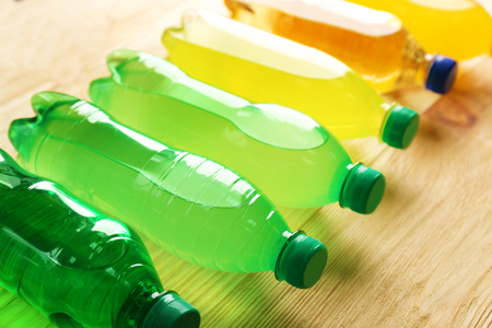 Soft drinks bottles on the wooden table, close upの写真素材