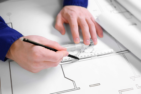 Male hands drawing line on a blueprint.の写真素材