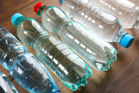 Bottled water on the wooden table, close upの写真素材
