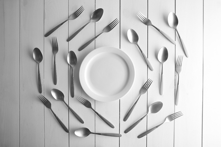 Plate and silver flatware on white table, top viewの写真素材