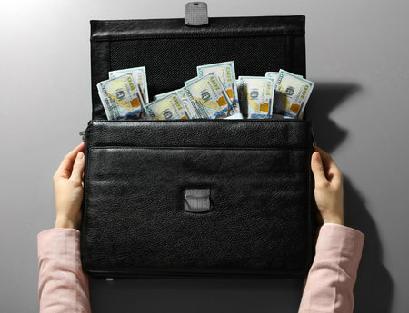 Businesswoman and brief case with money