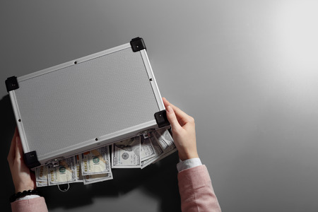 Businesswoman with case full of moneyの写真素材