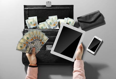 Businesswoman with money and gadgetsの写真素材