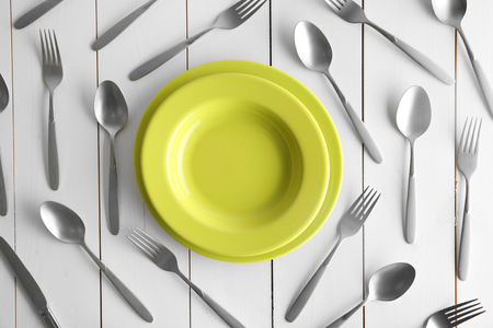 Plate and silver flatware on white table, top viewの写真素材