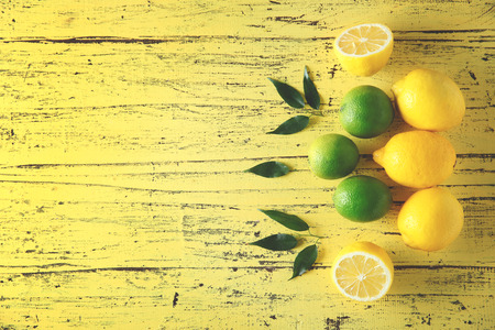 Fresh citrus fruits on a yellow wooden table.の写真素材