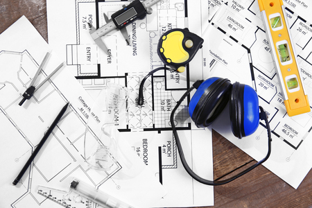 Blueprints and supplies on wooden table.の写真素材