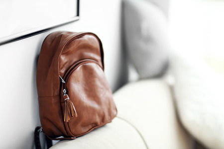 Brown leather backpack on the couch.