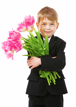 Schoolboy with bouquet of beautiful tulips isolated on whiteの写真素材