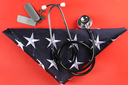 Stethoscope with tokens and stars of USA flag on red backgroundの写真素材