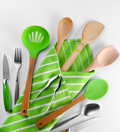 Set of kitchen tools with green napkin, isolated on whiteの写真素材