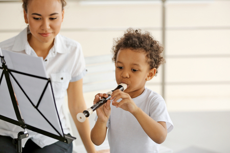 Young girl teaching little boy to playing on recorderの写真素材