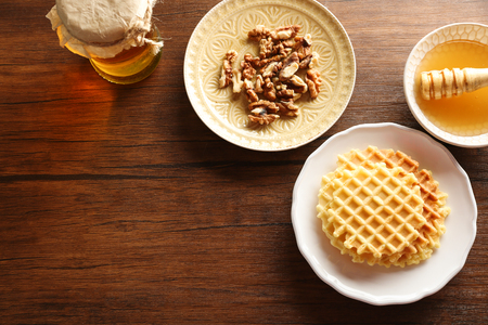 Waffles with walnuts and honey on wooden backgroundの写真素材