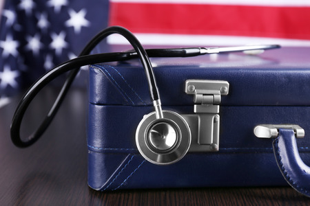 Stethoscope with blue suitcase on a tableの写真素材