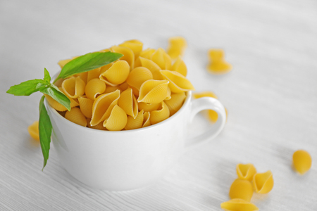 Fresh uncooked pasta in bowl on wooden table closeupの写真素材