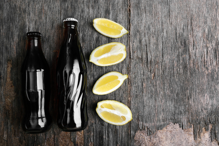 Soda bottles with lemon slices  on rustic wooden tableの写真素材