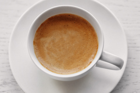 Cup of coffee on light wooden background, top viewの写真素材