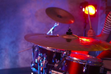 Drummer playing on drum set on stage.の写真素材