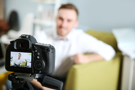 Young male blogger on camera screenの写真素材