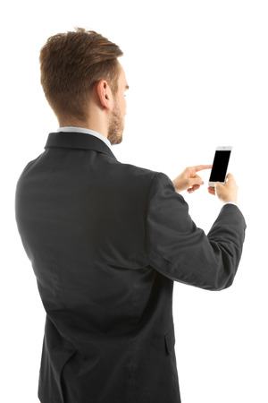 Young man in suit using mobile phone, isolated on whiteの写真素材