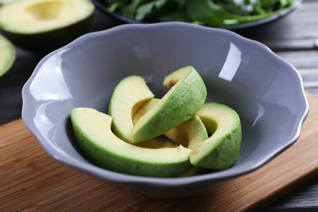 Plate with sliced avocado on cutting board, closeupの写真素材